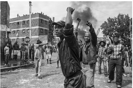 Pictures of men from Jeppestown making threatening gestures and brandishing axes, sticks and other weapons towards foreign-owned businesses in the neighbourhood.